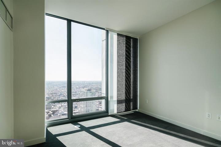 2101 Market Street, Unit 4205 Philadelphia, PA 19103 - Photo 16 of 31 an empty room with wooden floor and windows