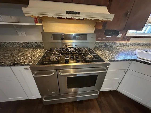 a stove top oven sitting inside of a kitchen