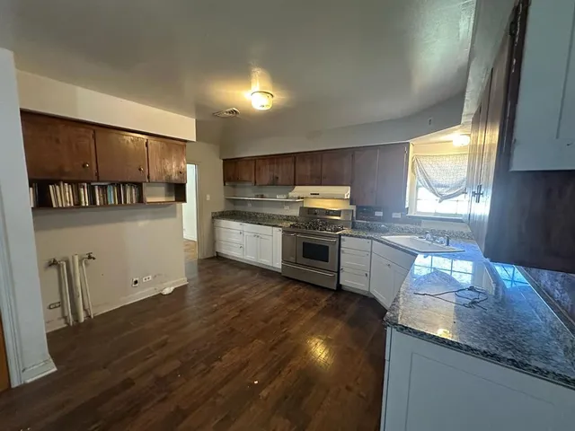 a kitchen with stainless steel appliances granite countertop a stove a sink and a refrigerator
