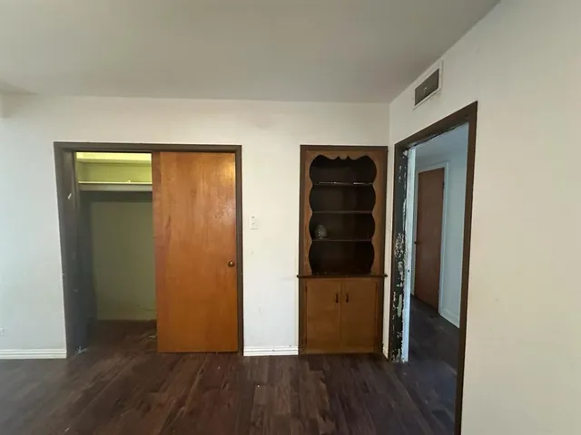 wooden floor in an empty room with a chandelier