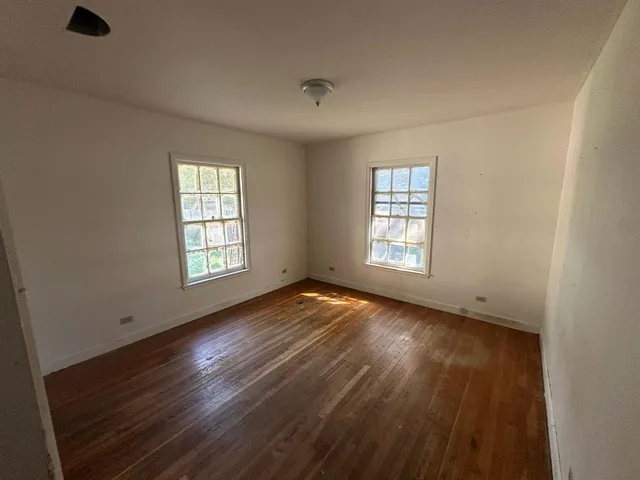 a view of hallway with wooden floor and stairs