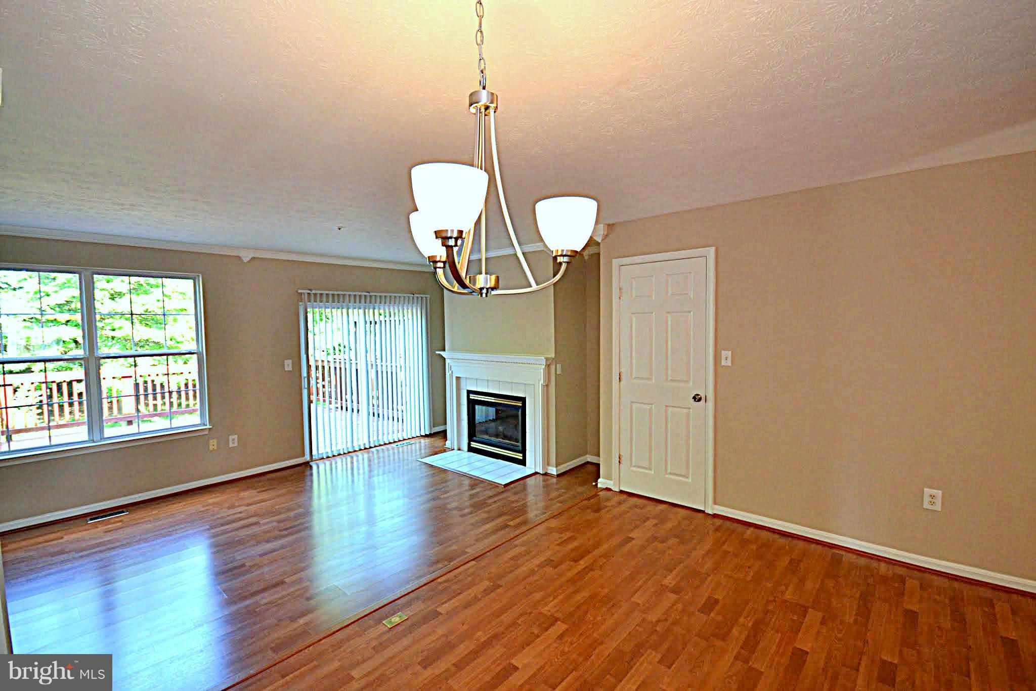 9044 Constant Course Columbia, MD 21046 - Photo 3 of 10 a view of empty room with wooden floor fireplace and window