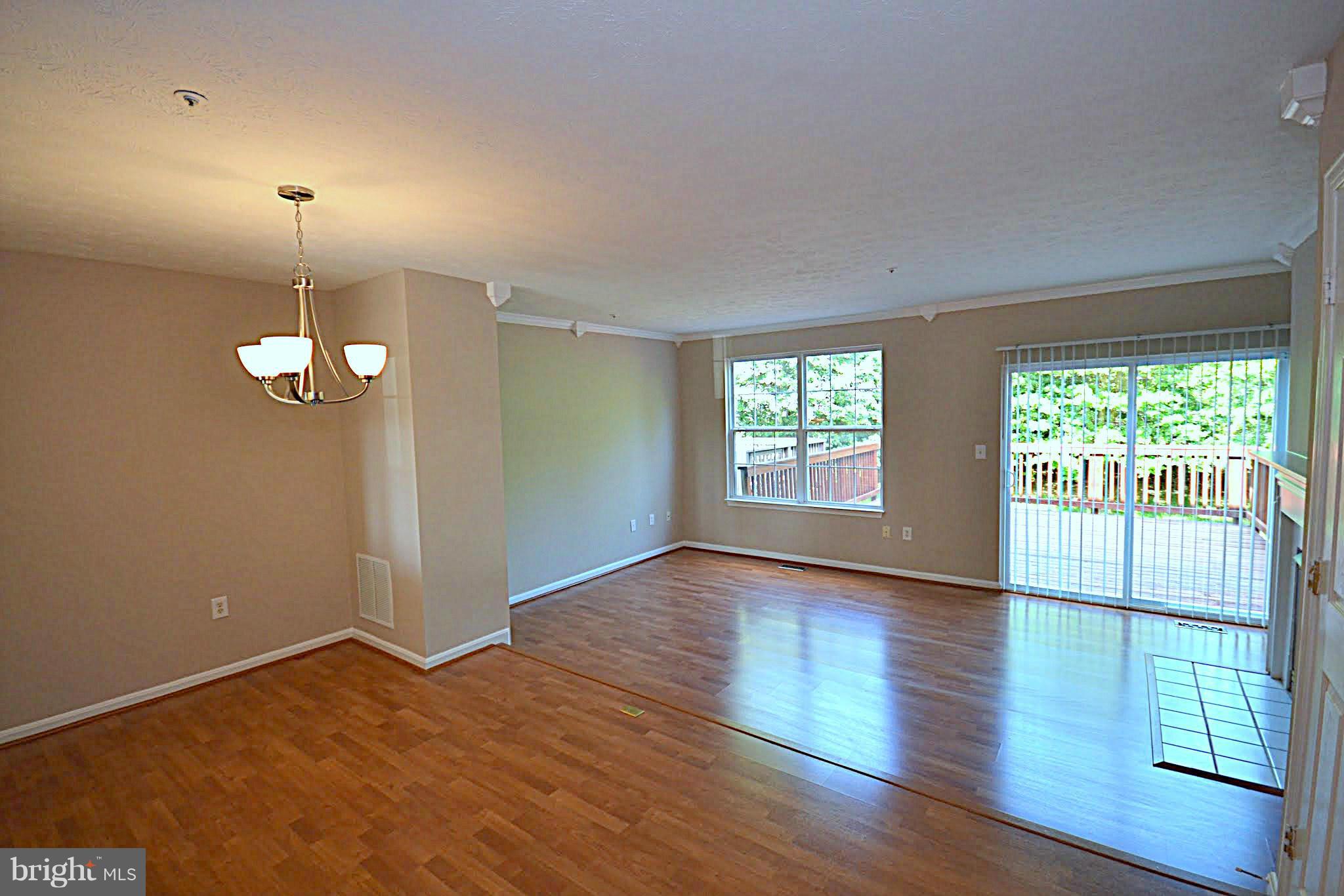 9044 Constant Course Columbia, MD 21046 - Photo 5 of 10 an empty room with wooden floor fan and windows