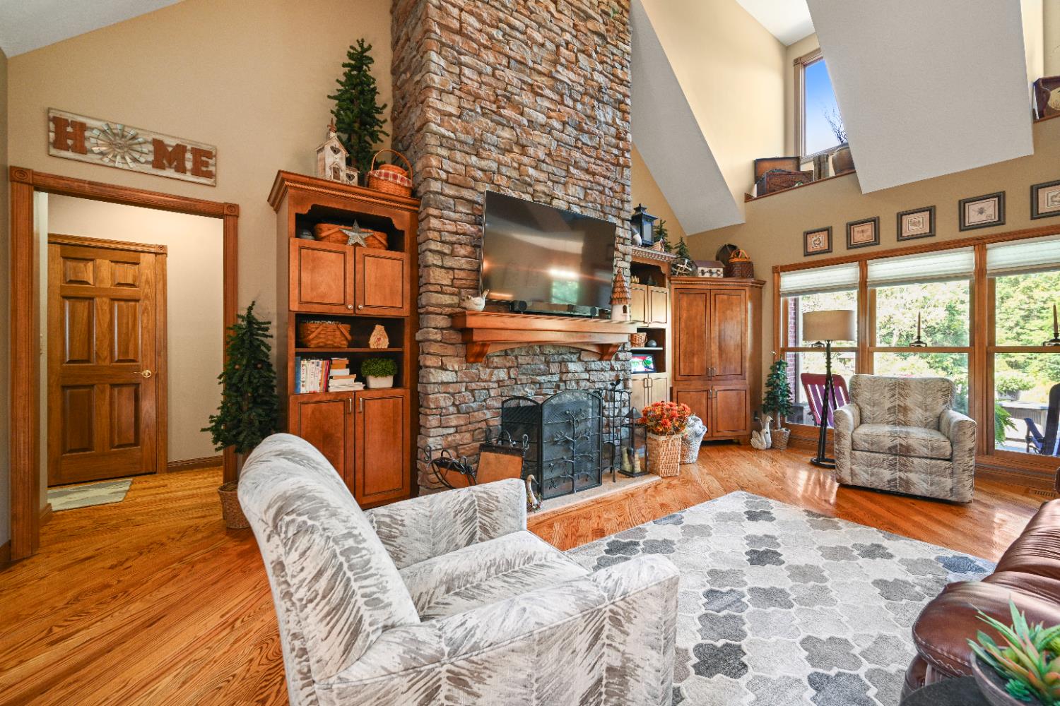 12656 Asche Road Sunman, IN 47041 - Photo 13 of 82 The 22 foot high vault in the Great Room creates a spacious feel. A striking stacked stone fireplace surrounded by custom built-ins is the focal point of the space. Polished hardwood floors & natural wood trim create a warm atmosphere, and large dormers & plentiful windows flood the space with natural light.