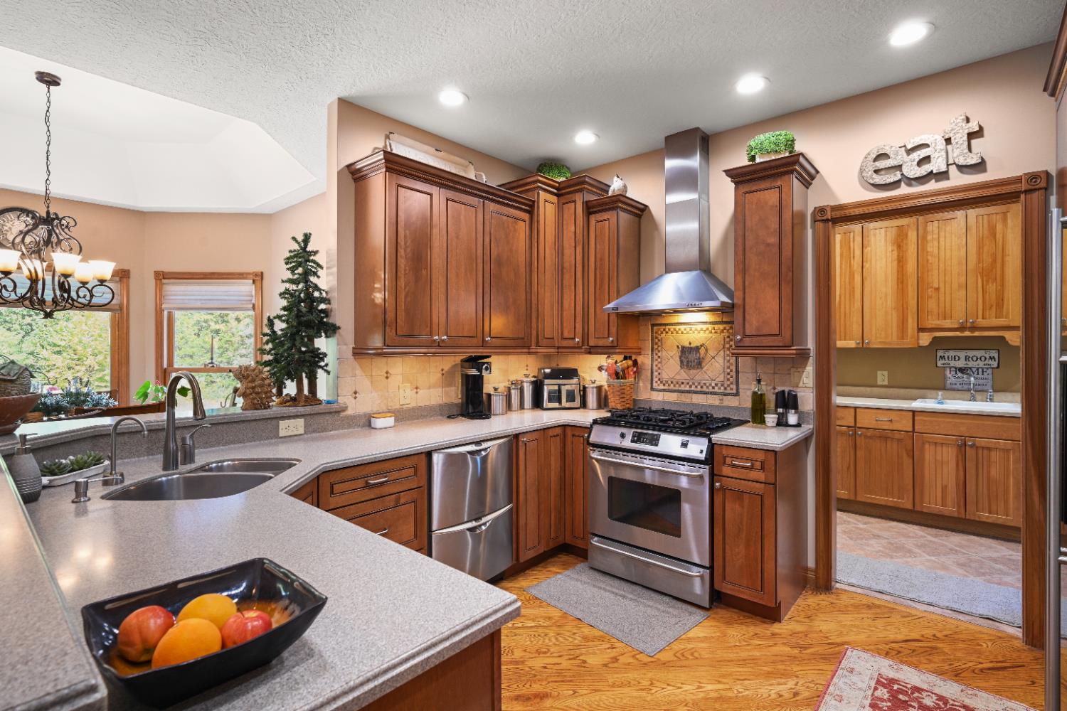 12656 Asche Road Sunman, IN 47041 - Photo 17 of 82 Plentiful solid surface countertops for food prep, plus gleaming stainless appliances... multi-height upper cabinets feature double crown molding with rope trim, as well as lower molding. Under cabinet lighting provides nice accent lighting.