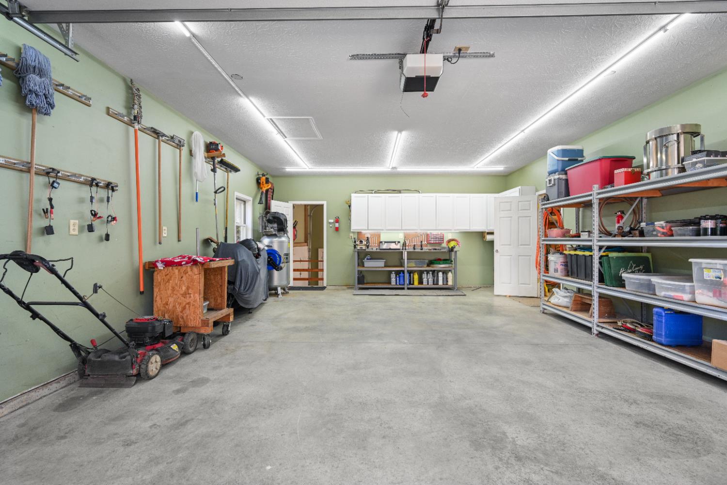 12656 Asche Road Sunman, IN 47041 - Photo 58 of 82 The attached car garage of the outbuilding is oversized, with cabinets, workbench, electric & LED lighting. The door at the far end opens into the attached drive-through RV garage across the back of the building.