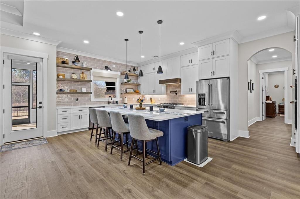 825 Arch Tanner Road Bethlehem, GA 30620 - Photo 13 of 58 a kitchen with stainless steel appliances a dining table chairs refrigerator and sink