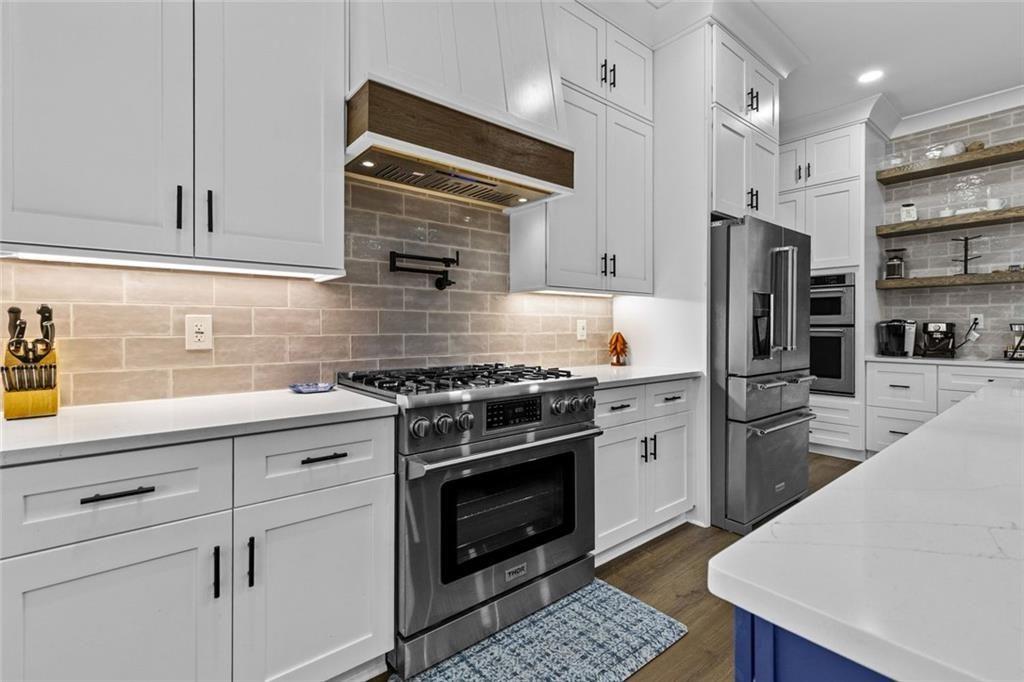 825 Arch Tanner Road Bethlehem, GA 30620 - Photo 19 of 58 a kitchen with stainless steel appliances white cabinets and a stove top oven