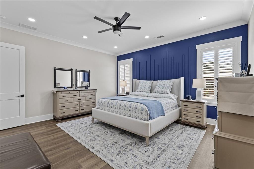 825 Arch Tanner Road Bethlehem, GA 30620 - Photo 25 of 58 a spacious bedroom with a large bed a chandelier and dresser