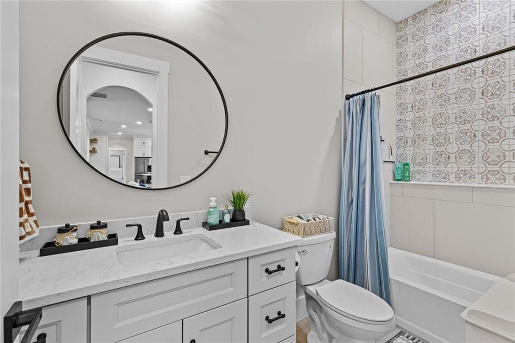 825 Arch Tanner Road Bethlehem, GA 30620 - Photo 33 of 58 a bathroom with a sink a mirror a toilet and a shower