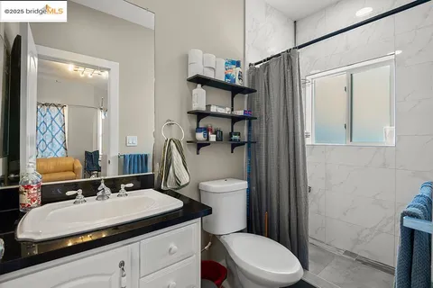 a bathroom with a sink toilet vanity and shower