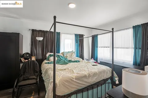 a bedroom with a bed window and a flat tv screen