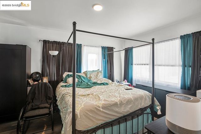 a bedroom with a bed window and a flat tv screen