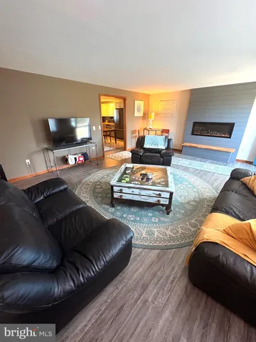 a living room with furniture a flat screen tv and next to a yard