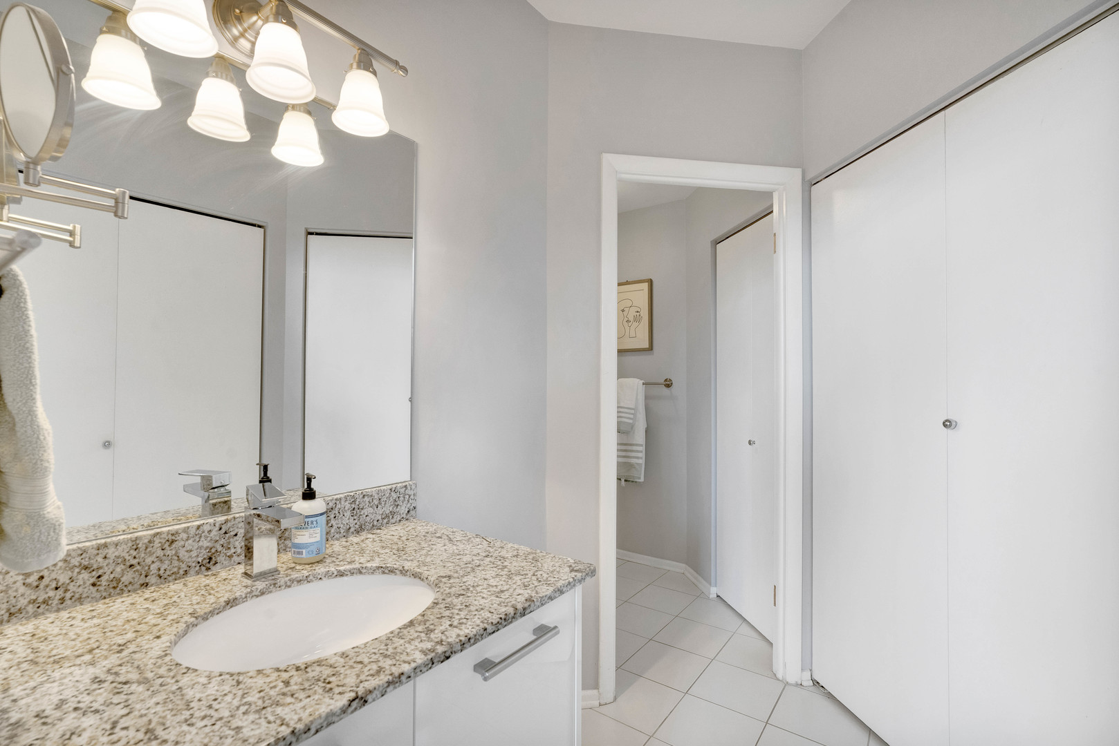 780 South Federal Street, Unit 1210 Chicago, IL 60605 - Photo 12 of 20 a bathroom with a granite countertop sink and a mirror