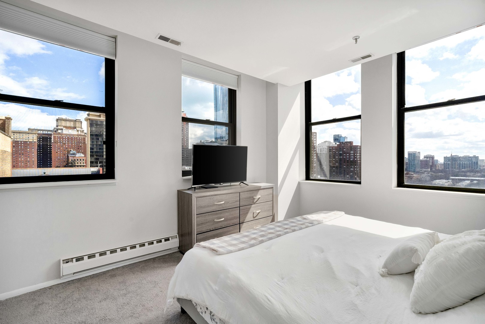 780 South Federal Street, Unit 1210 Chicago, IL 60605 - Photo 17 of 20 a bedroom with a bed and a flat tv screen on dresser