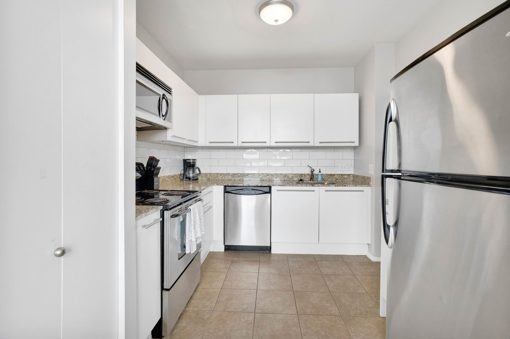780 South Federal Street, Unit 1210 Chicago, IL 60605 - Photo 7 of 20 a kitchen with white cabinets and white appliances
