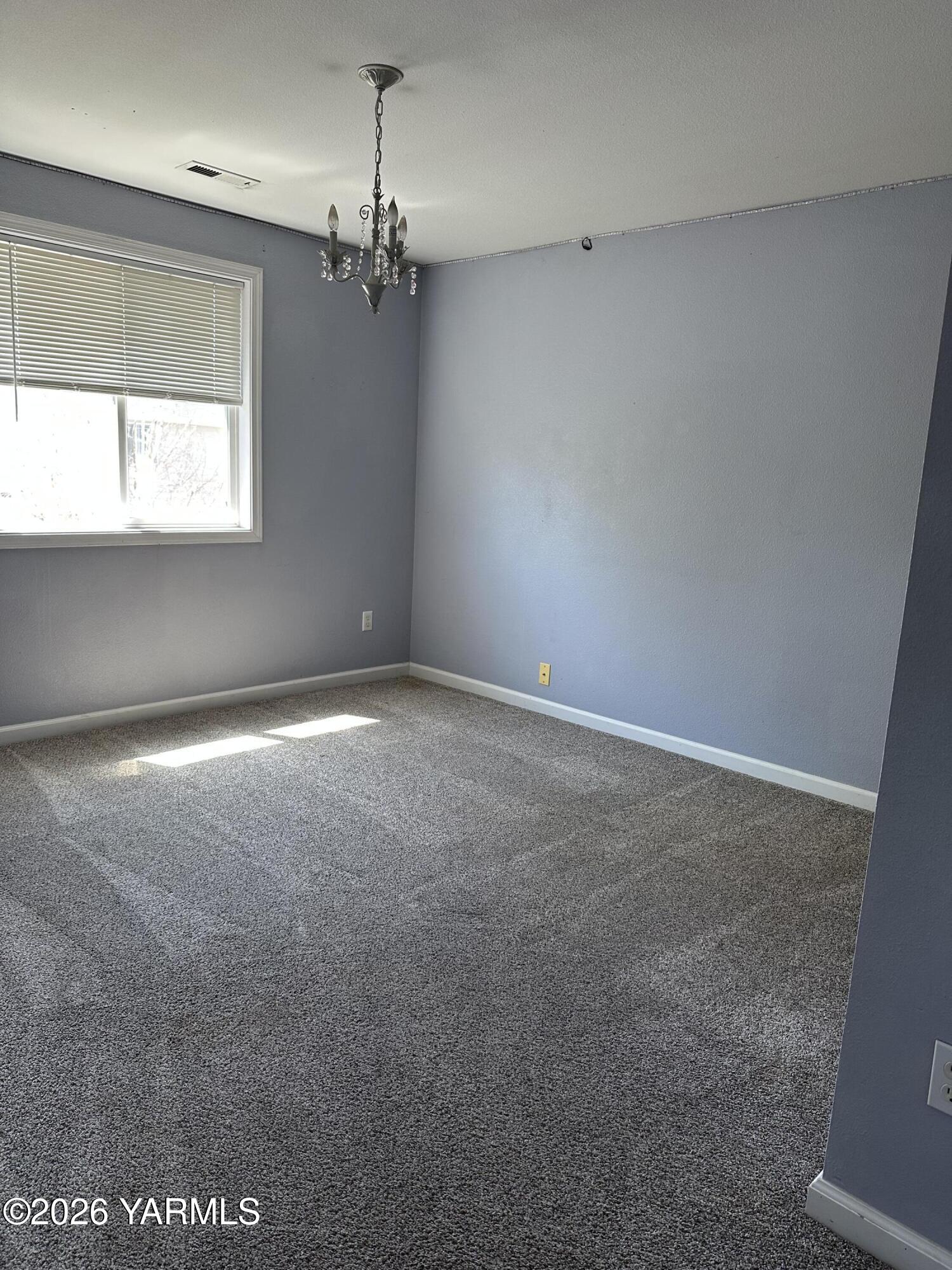 514 Cascade Avenue Moxee, WA 98936 - Photo 15 of 25 an empty room with a chandelier fan and windows