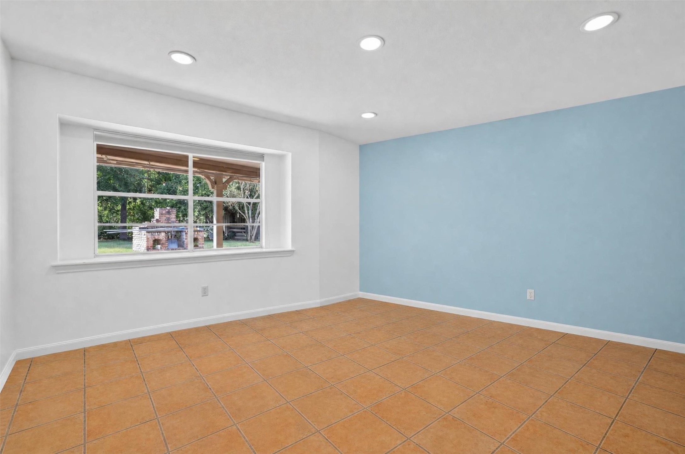 12625 Huffmeister Road Cypress, TX 77429 - Photo 23 of 50 A blank canvas filled with possibilities! This spacious third bedroom features natural light, a cheerful accent wall, and views of the backyard. Furnishings have been virtually removed to showcase the available space, allowing you to envision your own personal retreat, guest room, or creative space. The next chapter is yours to create!
