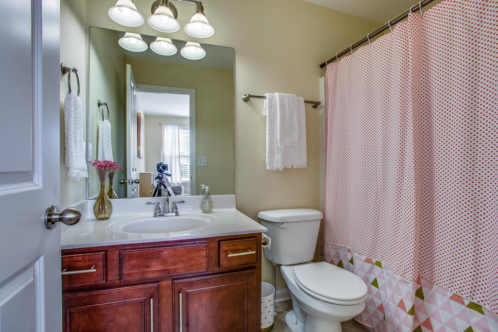 2046 Hemlock Drive Spring Hill, TN 37174 - Photo 24 of 28 a bathroom with a toilet a sink and mirror