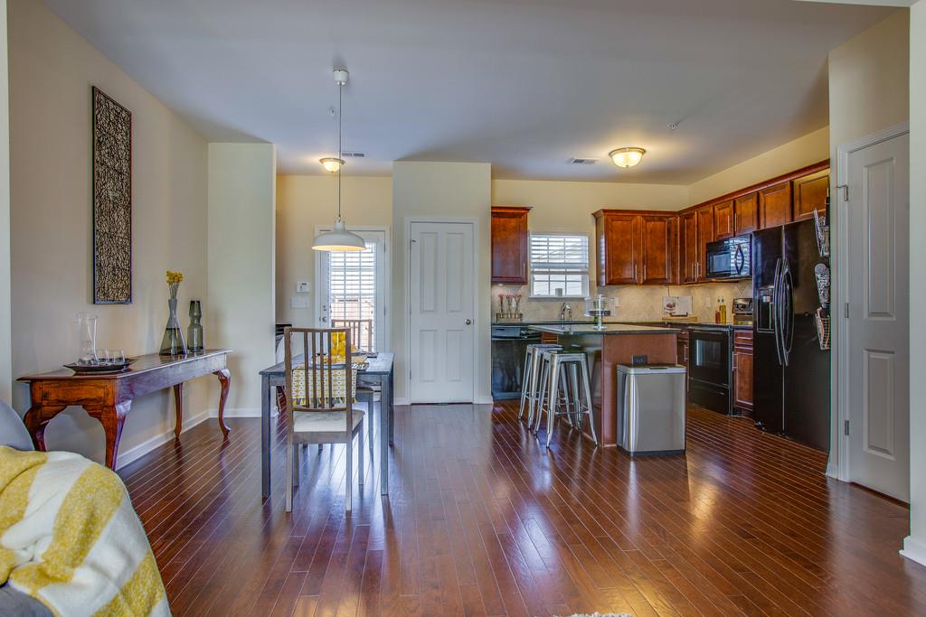 2046 Hemlock Drive Spring Hill, TN 37174 - Photo 5 of 28 a open kitchen with stainless steel appliances granite countertop a refrigerator a stove top oven a dining table and chairs with wooden floor