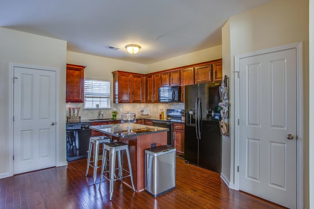 2046 Hemlock Drive Spring Hill, TN 37174 - Photo 6 of 28 a kitchen with a table chairs refrigerator and wooden floor