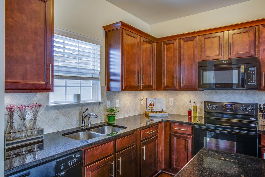 2046 Hemlock Drive Spring Hill, TN 37174 - Photo 8 of 28 a kitchen with stainless steel appliances granite countertop wooden cabinets a stove top oven a sink and dishwasher