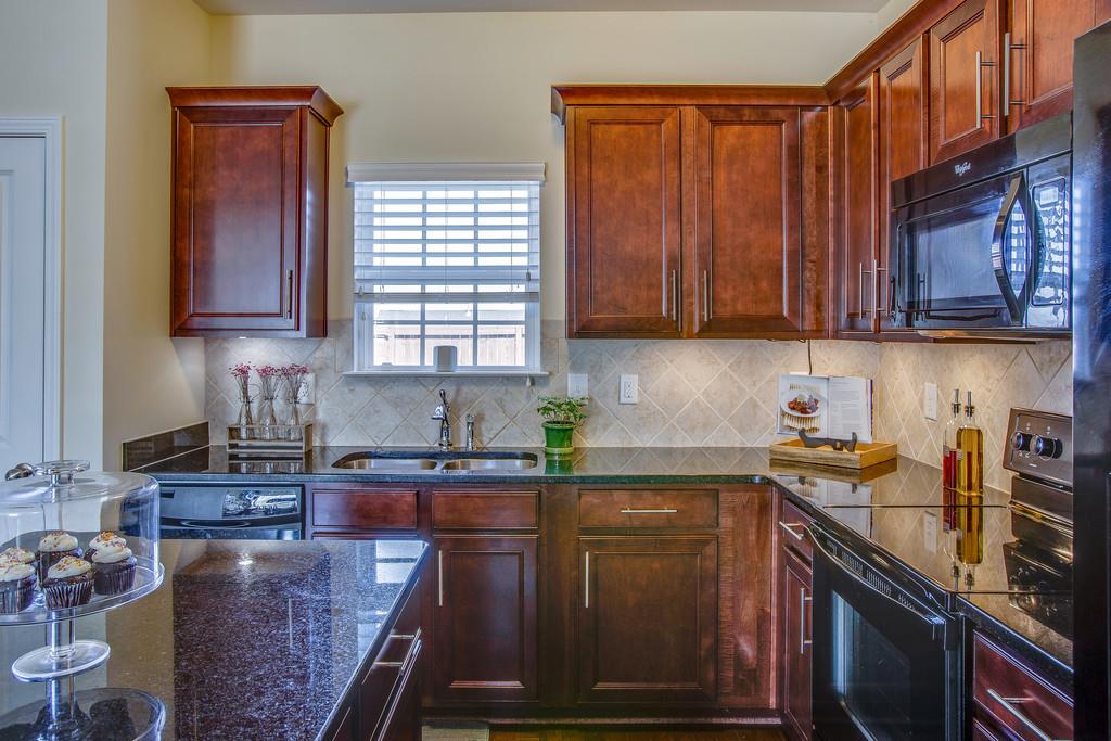 2046 Hemlock Drive Spring Hill, TN 37174 - Photo 9 of 28 a kitchen with granite countertop a sink a stove and cabinets