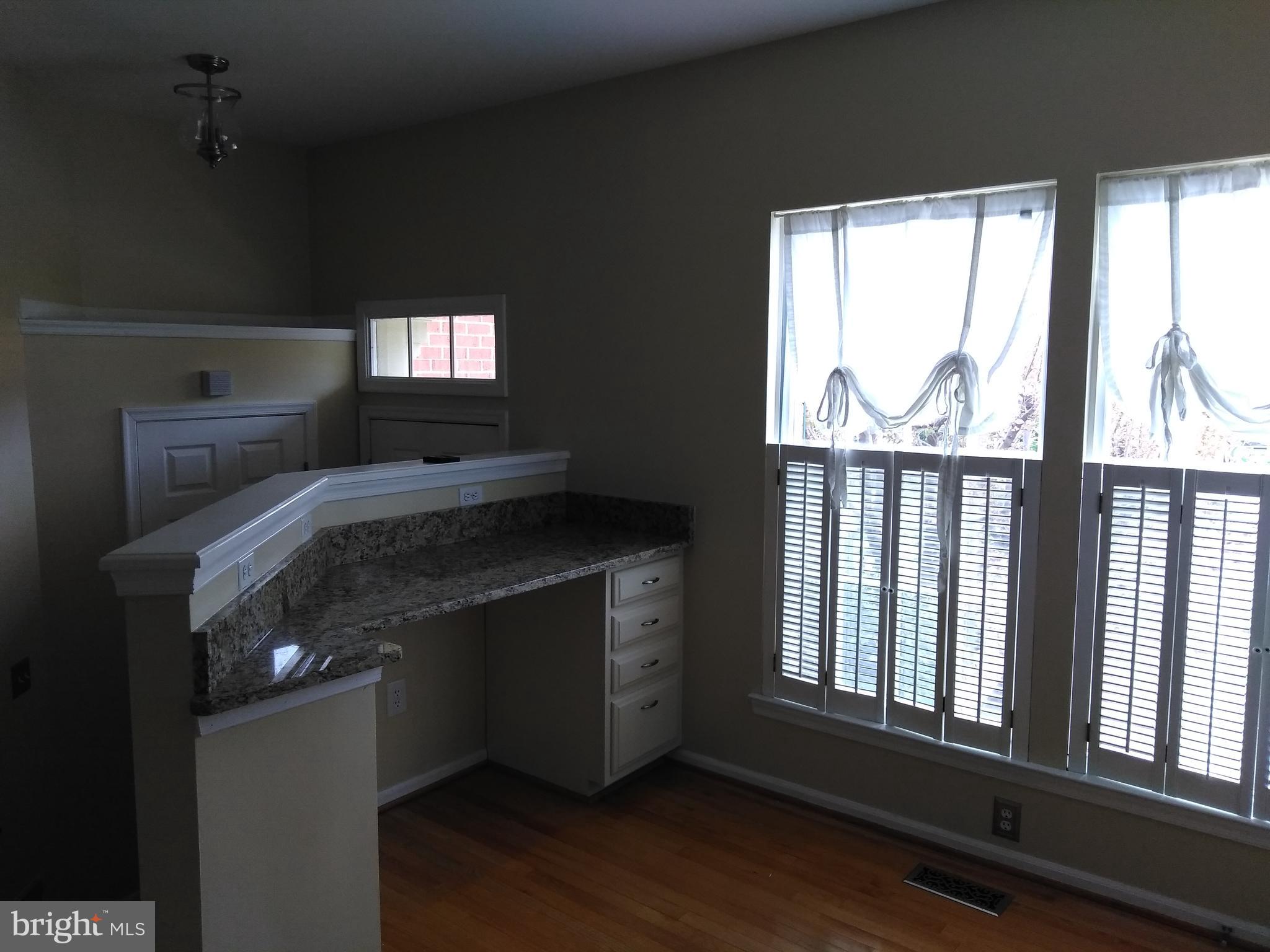 1384 Park Garden Lane Reston, VA 20194 - Photo 7 of 17 a kitchen with granite countertop a stove and a wooden floor