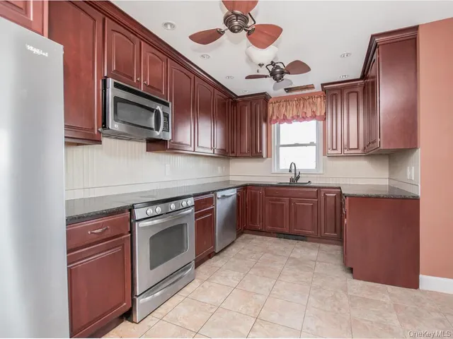 a kitchen with stainless steel appliances granite countertop a stove microwave and sink