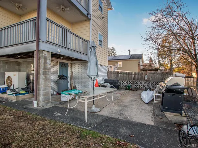 a backyard of a house with barbeque oven table and chairs