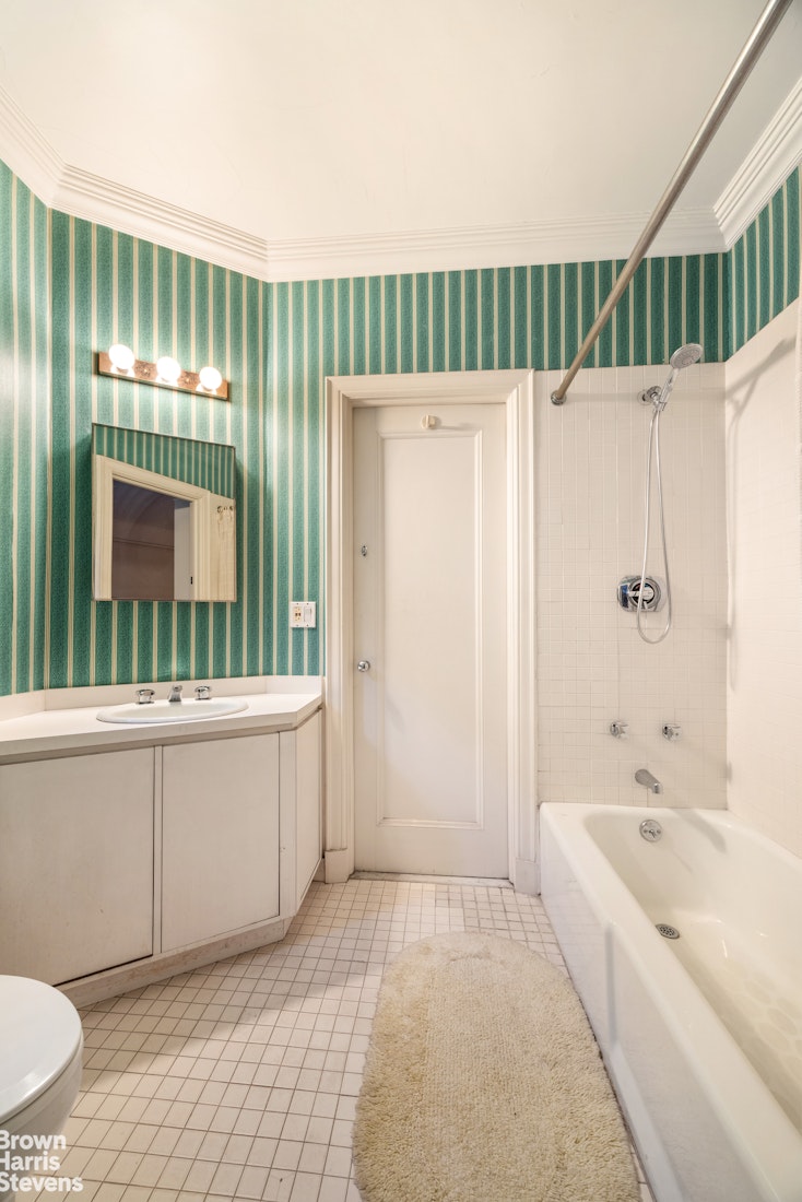 1075 Park Avenue, Unit 3D Manhattan, NY 10128 - Photo 19 of 20 a bathroom with a sink a mirror and a bathtub