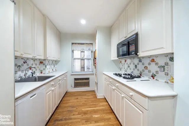 a kitchen with white cabinets and white appliances