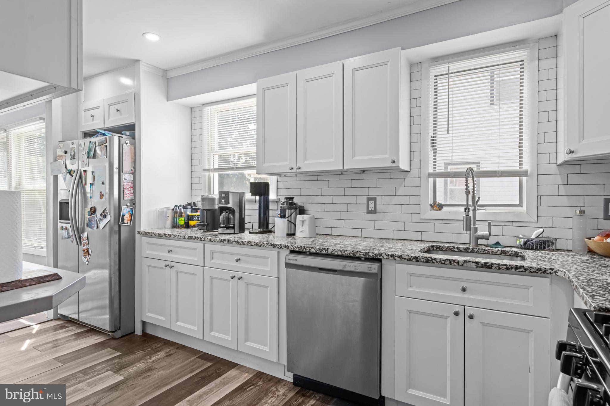 205 Nicholson Road Mount Ephraim, NJ 08059 - Photo 11 of 24 a kitchen with stainless steel appliances granite countertop a sink a stove a refrigerator and white cabinets with wooden floor