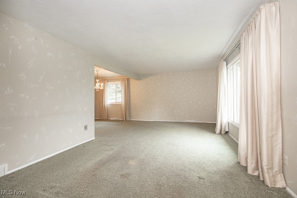 4569 McFarland Road Cleveland, OH 44121 - Photo 8 of 29 Carpeted spare room featuring a notable chandelier