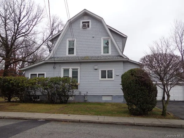 a view of a house with a yard and potted plants
