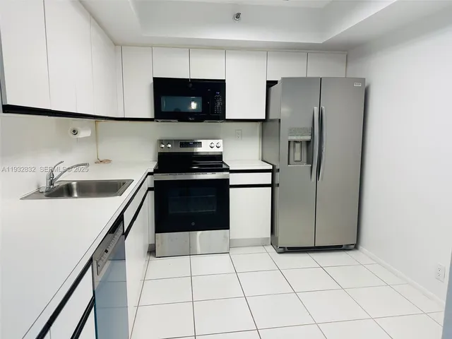 a kitchen with a refrigerator and a stove top oven