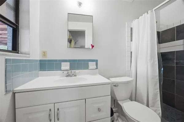 a bathroom with a sink toilet vanity and shower