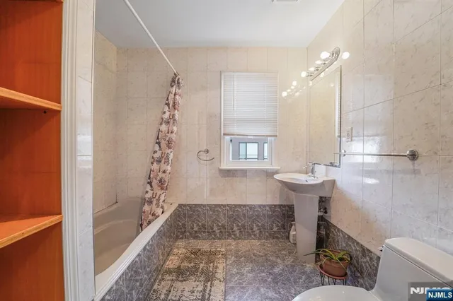 a bathroom with a tub a sink and a window