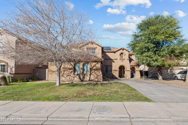 a view of a white house with a big yard and large tree