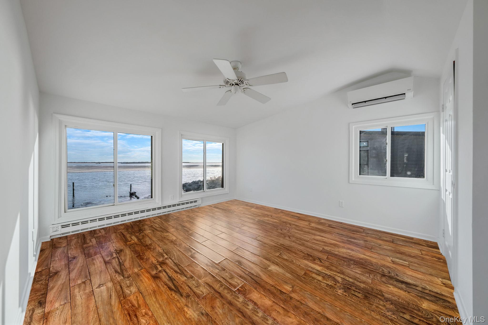 116 Oak Beach Road Babylon, NY 11702 - Photo 24 of 37 a view of an empty room with a window and wooden floor