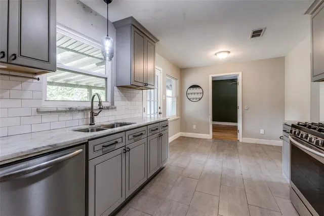 a kitchen with stainless steel appliances granite countertop a sink and a stove