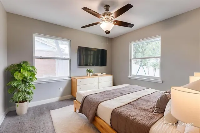 a bedroom with a bed television and a window