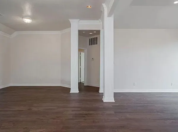 a view of an empty room with wooden floor and closet