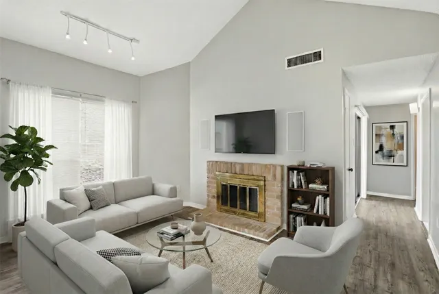 a living room with furniture a flat screen tv and a fireplace