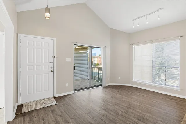 an empty room with wooden floor and windows