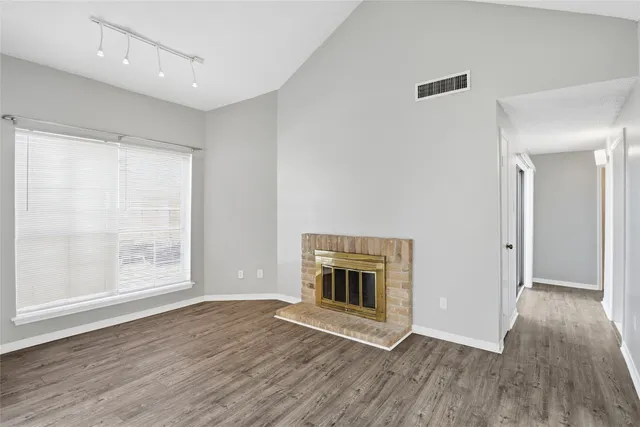 a view of empty room with wooden floor and fireplace