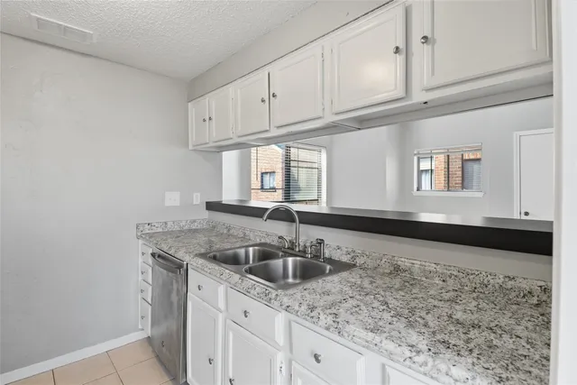 a kitchen with granite countertop a sink and cabinets