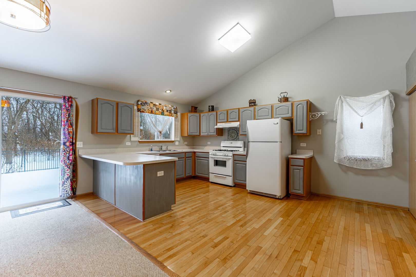 109 Shawnee Lane Harvard, IL 60033 - Photo 6 of 34 a kitchen with stainless steel appliances white cabinets and wooden floor