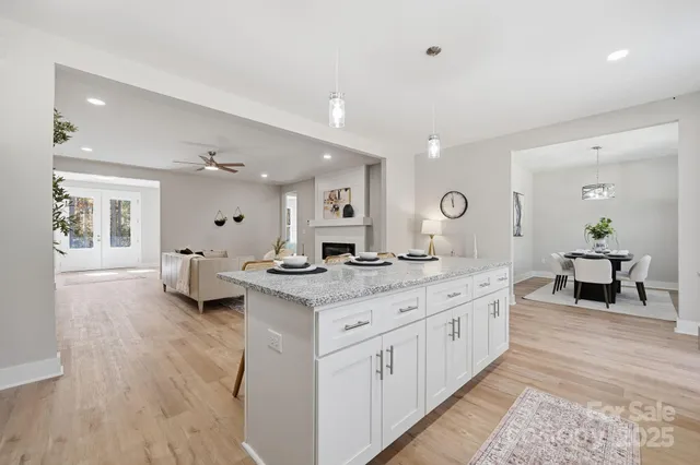 a kitchen with stainless steel appliances granite countertop a stove a sink and a white cabinets